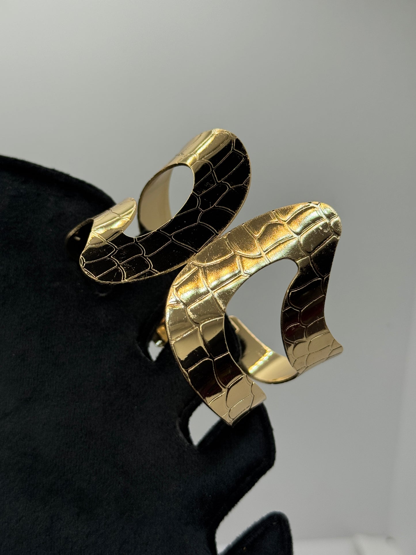Gold Cuff Bracelet with a Cut-out Wavy Design and a Crocodile Skin Texture