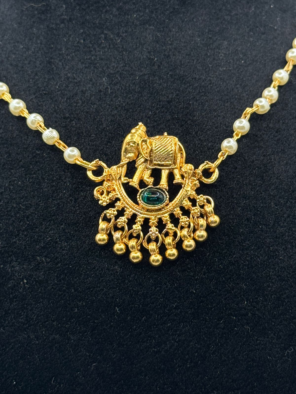 Necklace with elephant design and green emerald stud