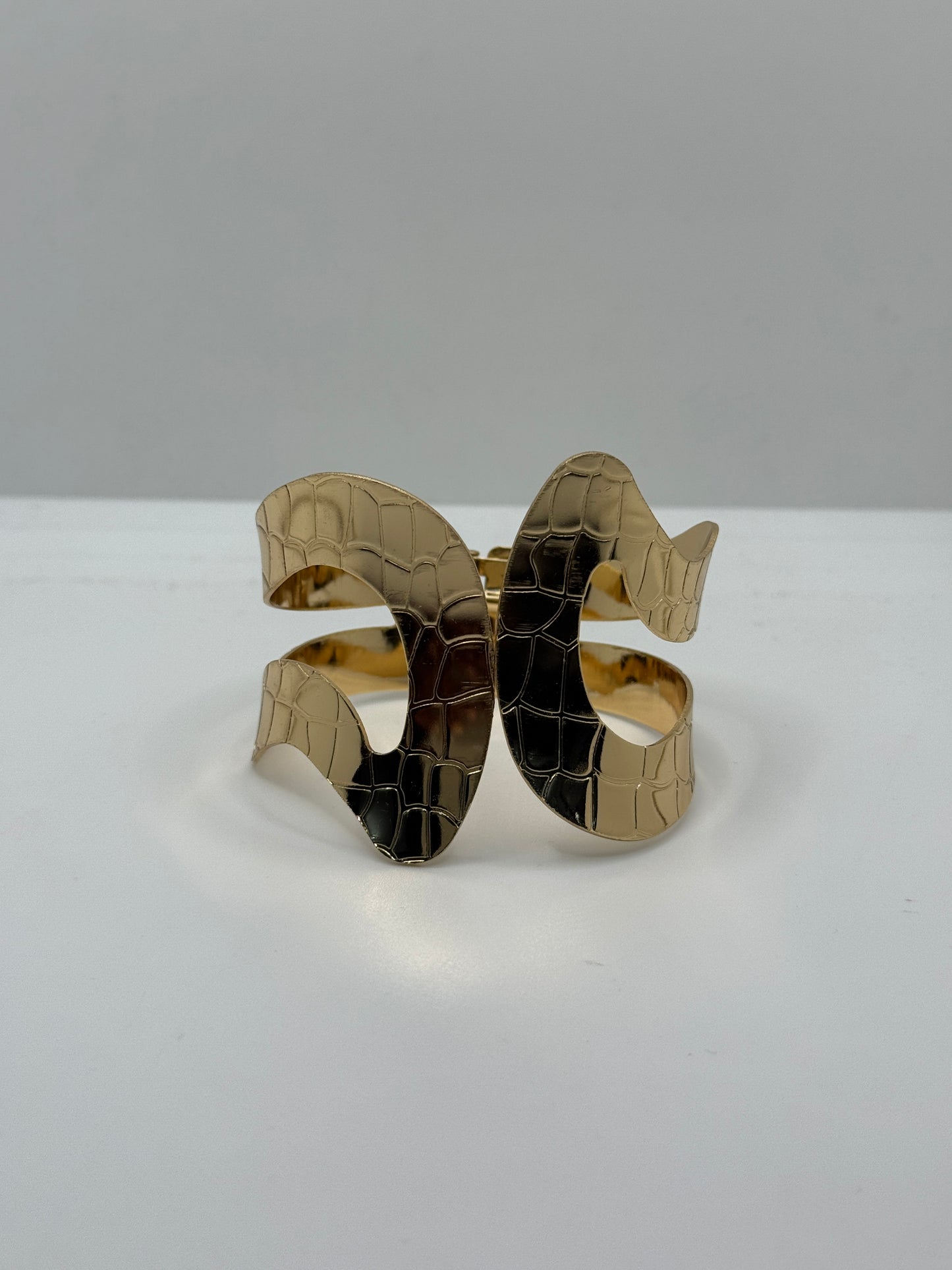 Gold Cuff Bracelet with a Cut-out Wavy Design and a Crocodile Skin Texture