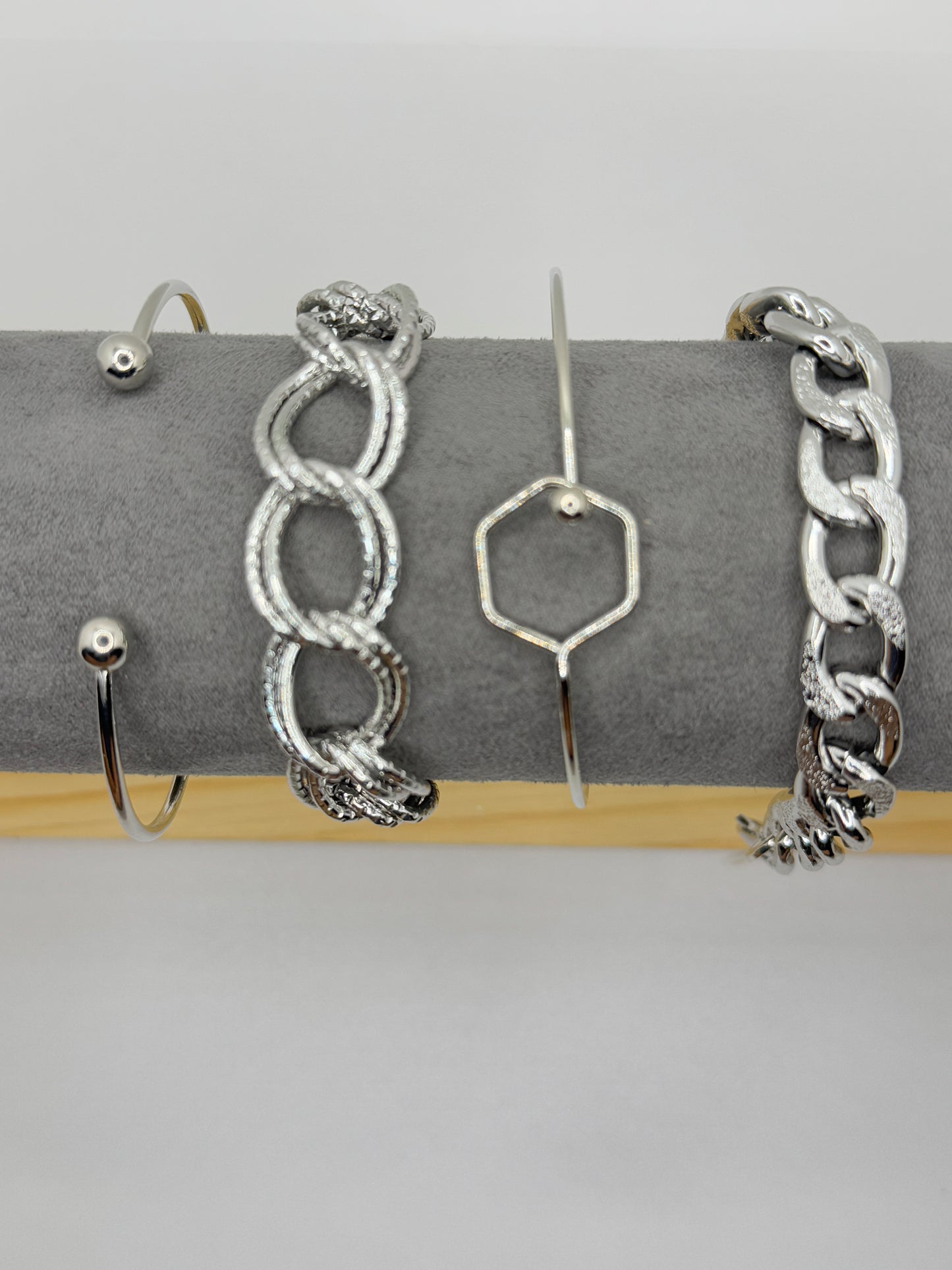 Four silver toned stacked bracelets