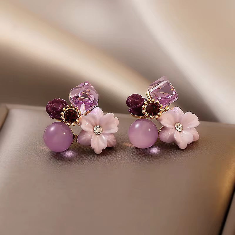 A pair of decorative stud earrings with a floral design.