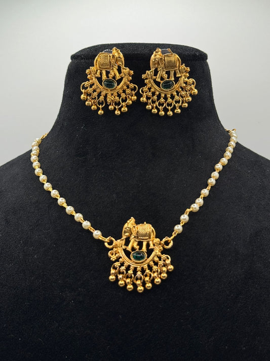 Necklace with elephant design and green emerald stud