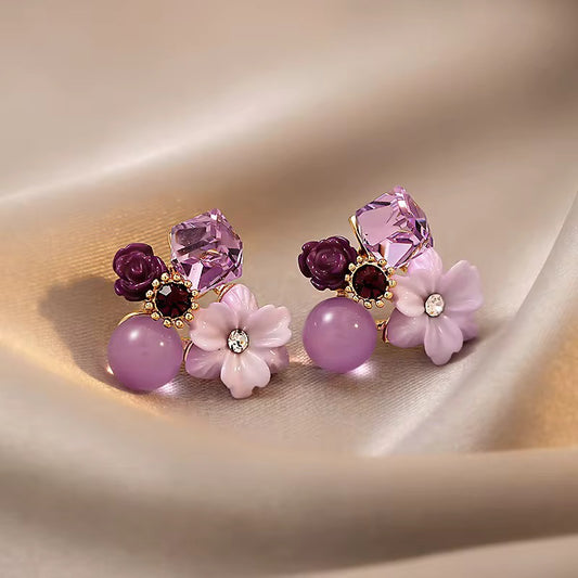 A pair of decorative stud earrings with a floral design.