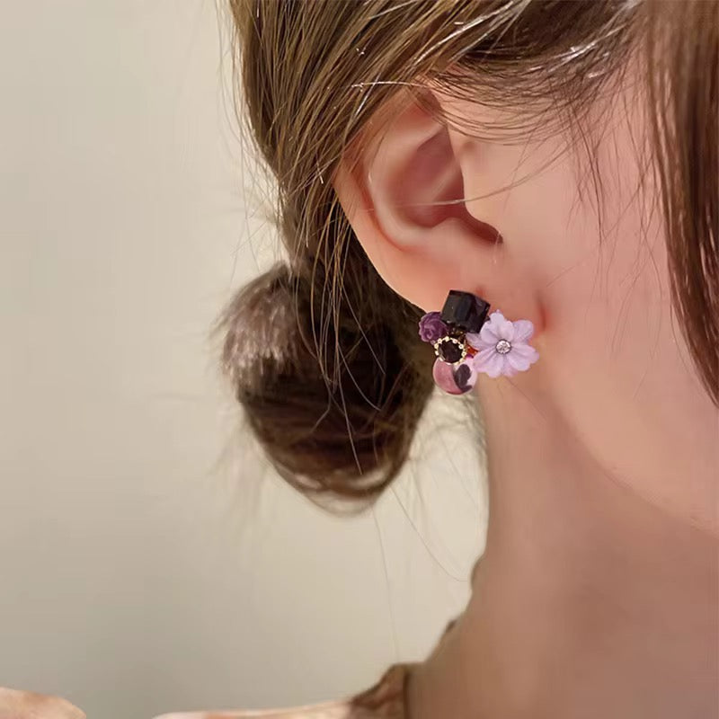 A pair of decorative stud earrings with a floral design.